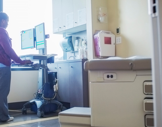 Nurse at a mobile computer desktop