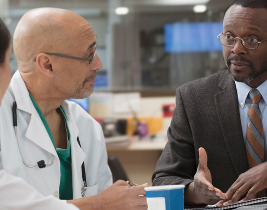 A hospital admin talking to two healthcare clinicians