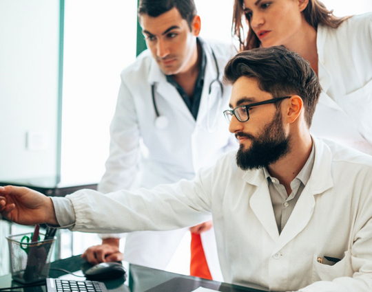 Group of doctors looking at a monitor screen