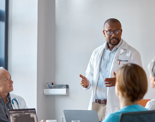 Medical expert giving presentation during meeting in office.