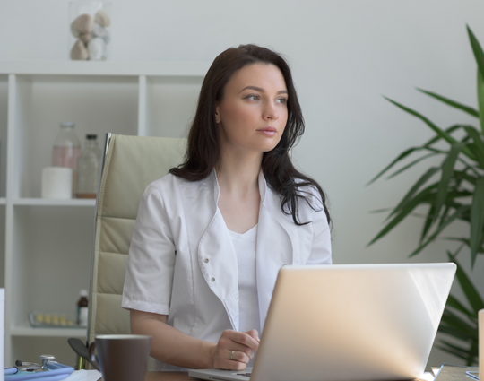 woman working at computer, looking away